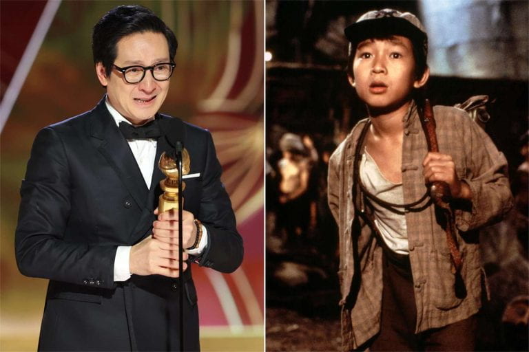 older man in glasses in suit and glasses holding Oscar in front of a microphone on the left and man as young boy in loose fitting clothing on the right.