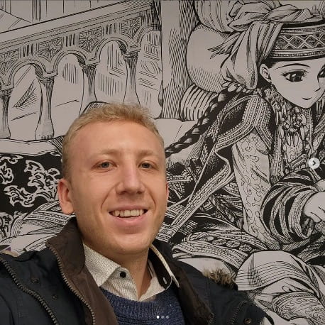 Man in selfie smiling in front of black and white anime mural