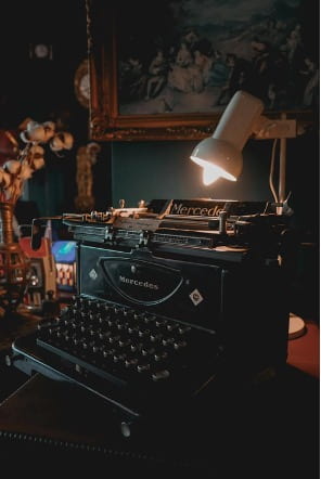An image of a typewriter surrounded by candles